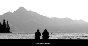 Two people relax by Lake Wakatipu, Queenstown, New Zealand