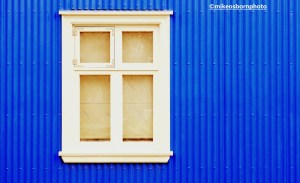 A window and bright blue wall in Reykjavik, Iceland