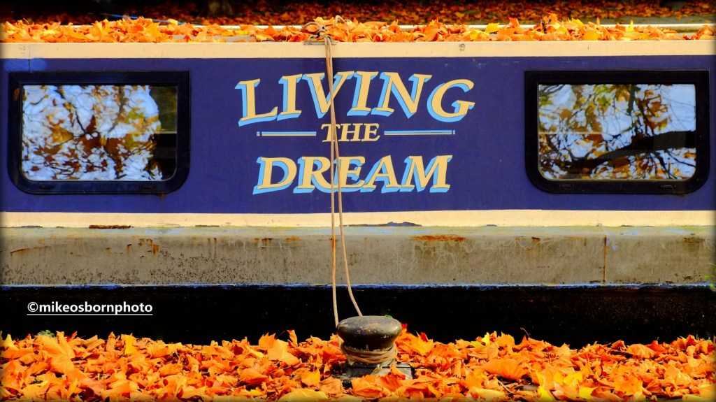A narrow boat in autumn on the canal at Castlefield in Manchester