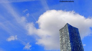 One of Deansgate Square towers against a dramatically clouded blue sky