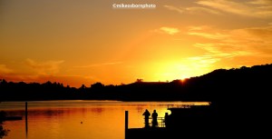 Golden sunset at Waitangi in New Zealand captures two fishermen