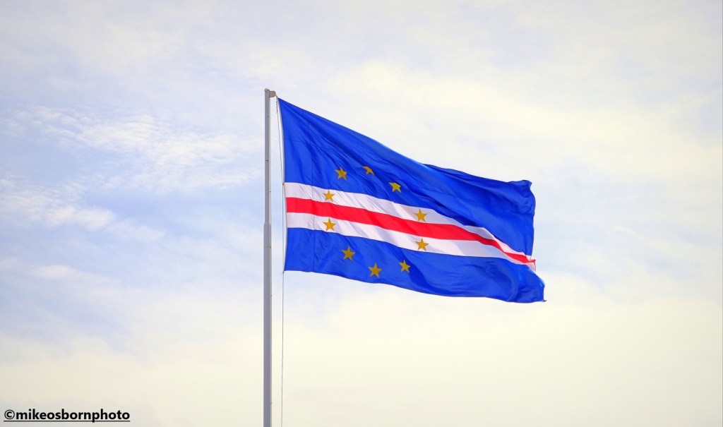 The flag of Cape Verde flying above the capital city Praia