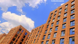 The open windows of a canalside apartment block in Manchester on a bright summer's day