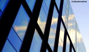 A new glass office block in Manchester reflects the sun and sky.