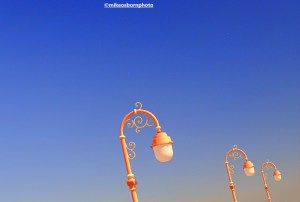 The pink lamps of Colwyn Bay pier in Wales set against a pristine blue sky