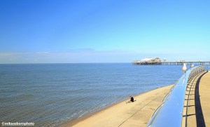 A man rests on the concrete sea defences that line Blackpool sea front.