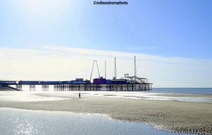 A view of Blackpool beach and the resort's South Pier on a sunny autumn day.