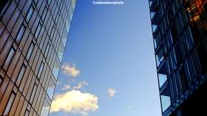 The blue sky blazes between two adjacent apartment blocks in Manchester.