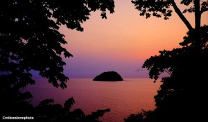 A pink-hued sunrise capturing Santana islet in São Tomé.
