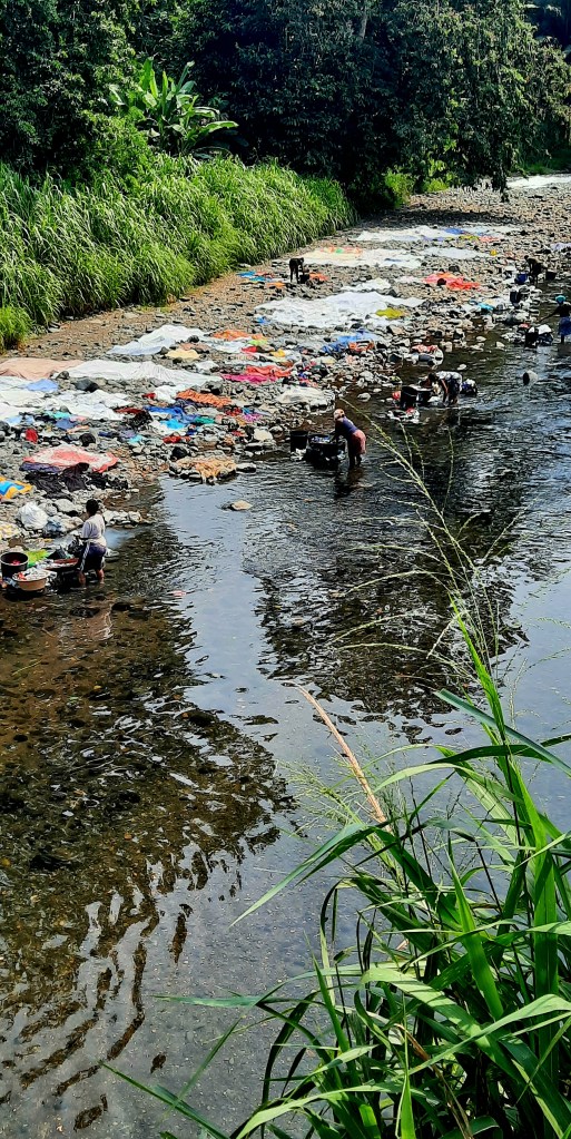 Women in São Tomé washing clothes at a river in the African island country.
