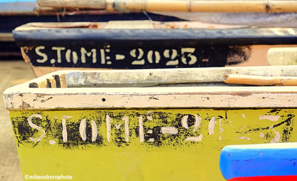Colourfully painted fishing boats moored on the coast of São Tomé island.