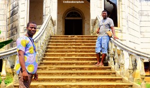 Two tour guides pose on the dilapidated stairway of Roça Agua-Ize in São Tomé.