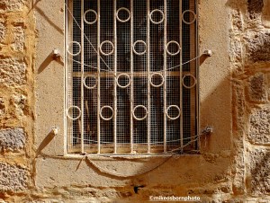 A window with an old grille on a back street of Perast, Montenegro.