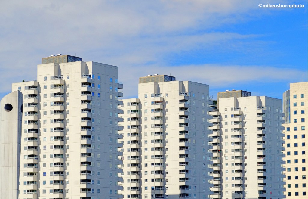 A trio of white apartment blocks by the river in Rotterdam, the Netherlands.