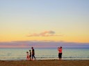 A family of four enjoy a sunset walk on the shores of Costa Calma in Fuerteventura.
