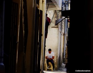 A man scrolls on his smartphone in the narrow alleyways in Matsamudu's old city in the Comoros Islands.