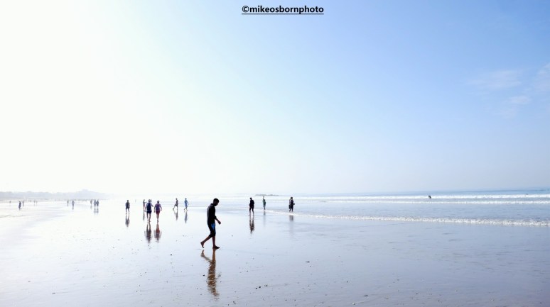 Visitors on a shimmering shoreline on Agadir beach in Morocco.