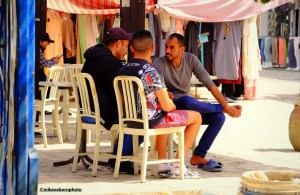 Three men get together in a square of Houmt Souk in Djerba, Tunisia.