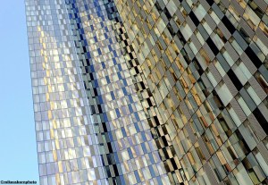 A cluster of glass high rise buildings in Manchester catching reflections of the sun.
