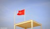 A Tunisian flag flying over a lifeguard platform on a beach in Djerba, Tunisia.