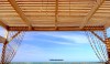 A covered wooden sun platform with a sea view at the Waves Mehari hotel in Djerba, Tunisia.