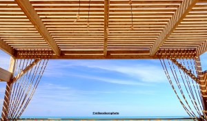 A covered wooden sun platform with a sea view at the Waves Mehari hotel in Djerba, Tunisia.