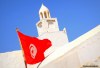 A pure white minaret and the red Tunisian flag on the island of Djerba.