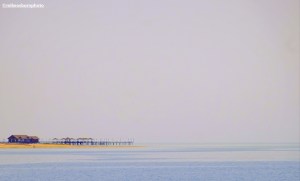 A minimalist view of a beach and pier on the shores of Lake Issyk-Kul in Kyrgyzstan.