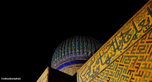The Khoja Ahmed Yasawi mausoleum building illuminated at night.