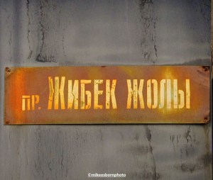 A battered street sign for Silk Road, one of Almaty's well-known thoroughfares.