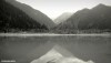 A monochrome image of a view of the mountains across Lake Issyk in Kazakhstan.