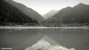 A monochrome image of a view of the mountains across Lake Issyk in Kazakhstan.