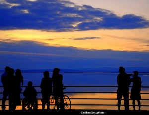 The silhouettes of sunset watchers caught against the colours over Morecambe Bay.