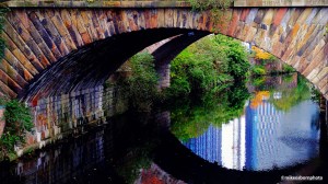 Reflections of the Vista River Gardens skyscrapers reflected in the water by the River Irwell railway bridge.