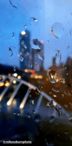 A rain-spattered window pane looking out onto Castlefield in Manchester.