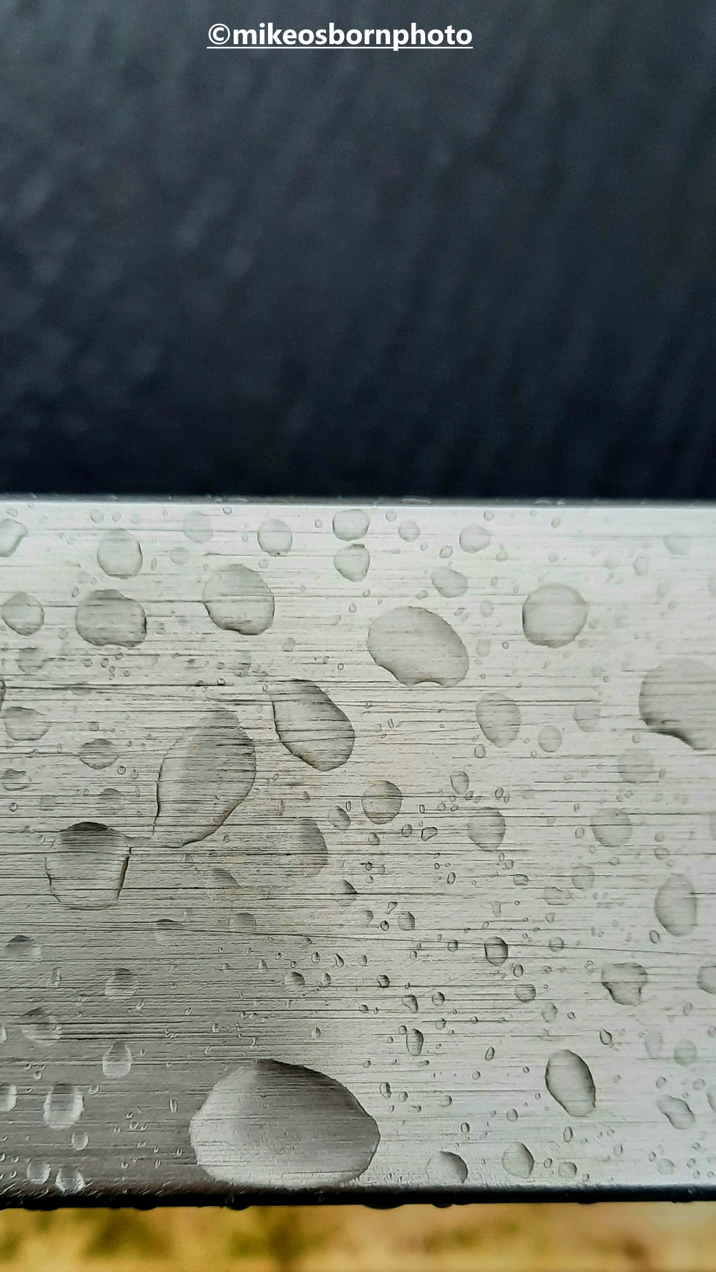 Raindrops on the metal handrail of Merchant's Bridge in Castlefield, Manchester.