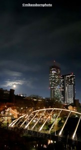 The moon rising at night over Castlefield in Manchester.
